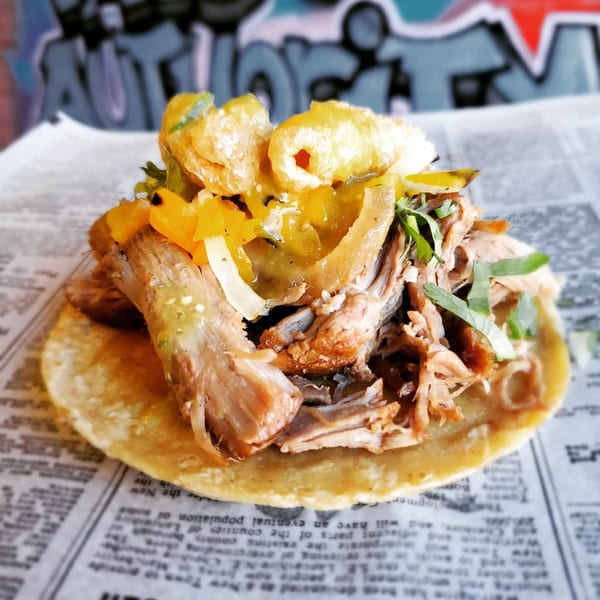 A Chicago Taco Authority carnitas taco with chicharrones, yellow peppers, and cilantro.
